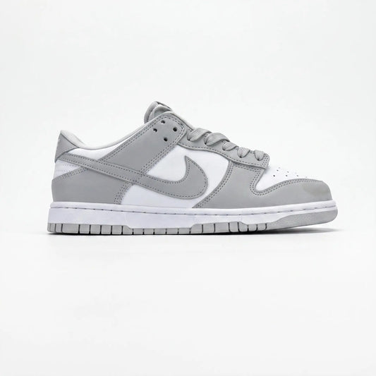 A Nike Dunk sneaker in a light gray and white colorway, shown from the side profile against a clean white background.