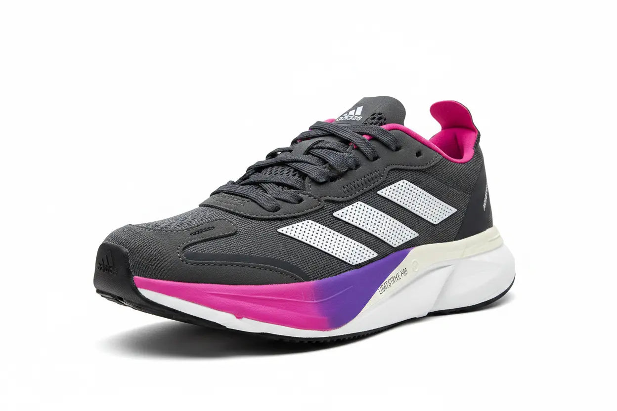 An Adidas running shoe in dark gray with white three-stripes, a bright pink collar, and a purple-to-pink gradient midsole on a white background.