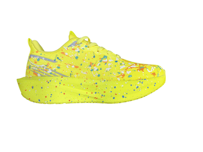 A single neon yellow sneaker shown in a side profile view against a solid white background, featuring a vibrant paint splatter pattern in blue, orange, red, and white.
