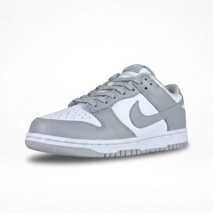 A Nike low-top sneaker in light gray and white, featuring a gray leather upper with white overlays, gray laces, and a white midsole.