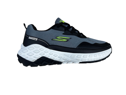 A Skechers running shoe shown from a side profile view, featuring a dark gray and black upper with a prominent white midsole and a bright green logo accent.
