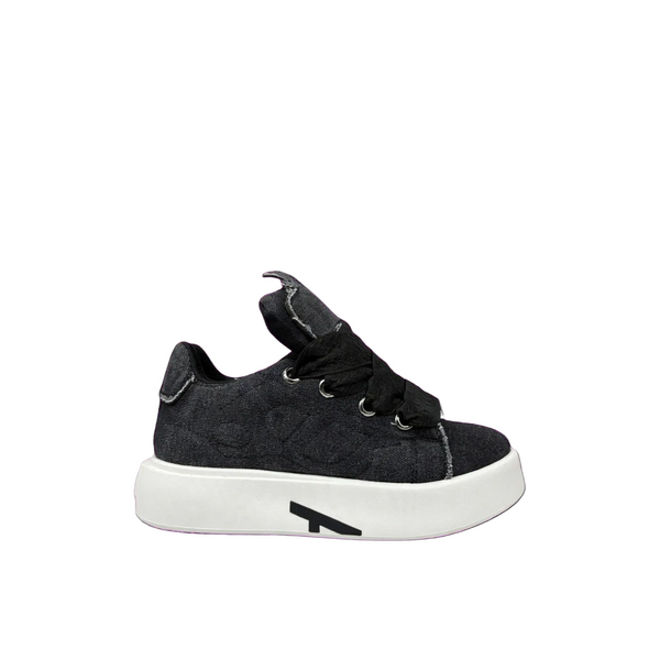 A single black quilted sneaker with a chunky white platform sole and a black geometric logo on the side, shown against a plain white background.